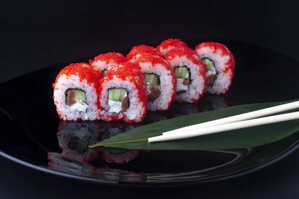 Rollos de california con pepino y salmón sobre plato negro — Foto de Stock