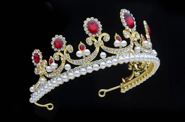 Corona dorada con rubíes y perlas sobre fondo negro — Foto de Stock