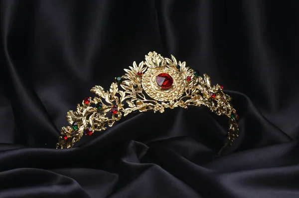 Zlatá koruna s rubíny na černém hedvábí — Stock fotografie