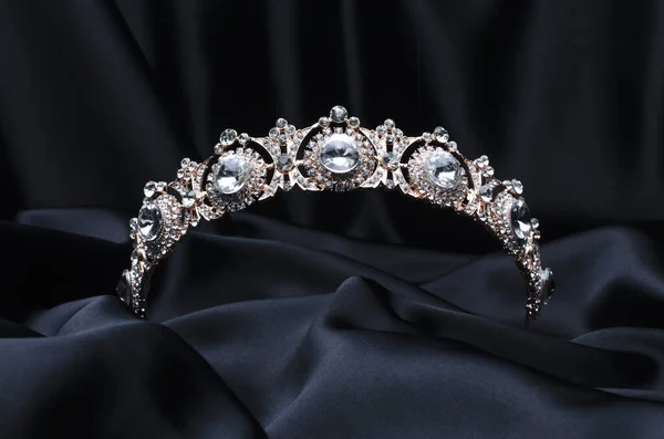 Gyllene tiara med diamanter på svart siden — Stockfoto