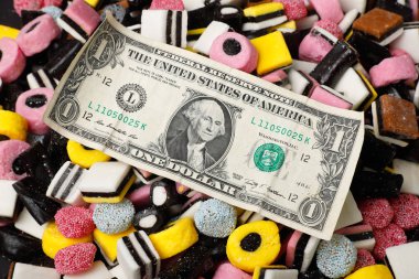 Dollar bill on assorted English liquorice cany