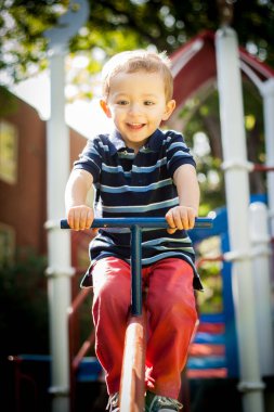 Mutlu gülümseyen çocuk parkta oynuyor.