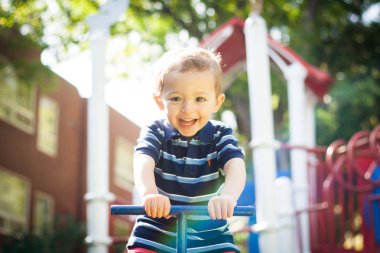 Mutlu gülümseyen çocuk parkta oynuyor.