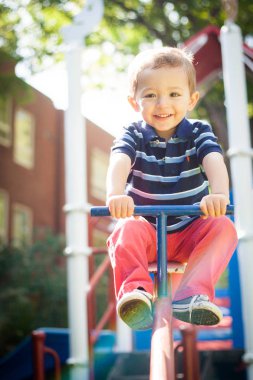 Mutlu gülümseyen çocuk parkta oynuyor.