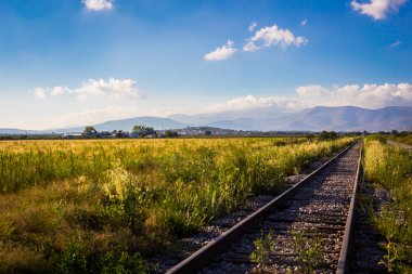 Demiryolu gün batımı, dağlar ve mavi gökyüzü.