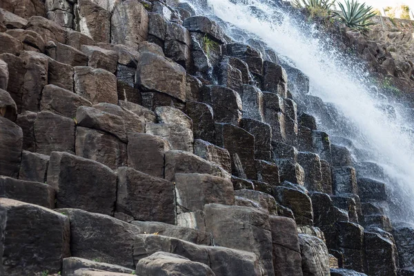 Waterfall and a hanging bridge at basaltic prism canyon at Hidalgo, Mexico.