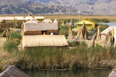 Puno, Peru, Ekim. 16. 2012: Titicaca Gölü 'ndeki uros adalarında yüzen evler ve totora tekneleri.