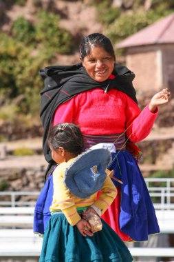 Anne ve kızı geleneksel kıyafetleriyle Puno-Peru 'da oynuyorlar..