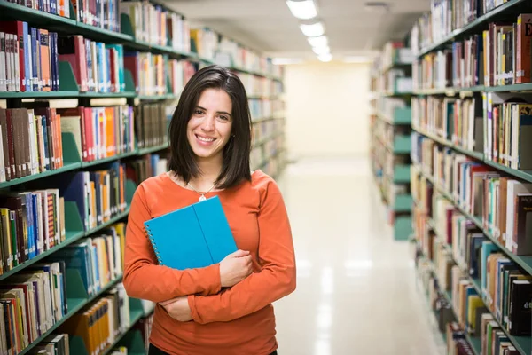 図書館で 高校図書館で働く本を持つかなり女性の学生 — ストック写真