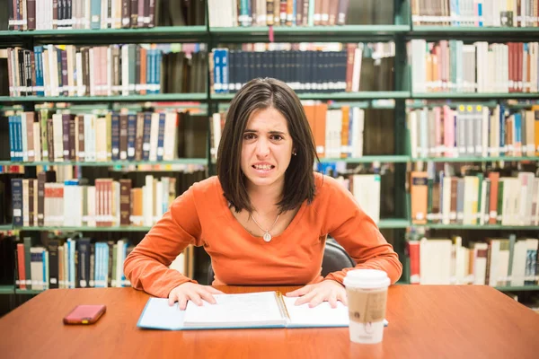 Na biblioteca - estresse estudante muito feminino com livros de trabalho — Fotografia de Stock