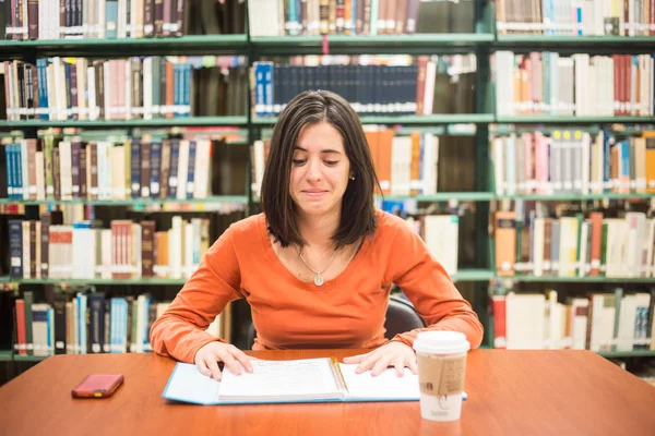 In the library - pretty female student thinking working in a hig — Stock Photo, Image