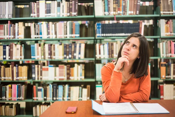 In de bibliotheek - vrij vrouwelijke student denken werken in een hig — Stockfoto