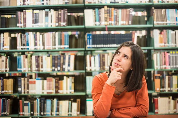 In de bibliotheek - vrij vrouwelijke student denken werken in een hig — Stockfoto