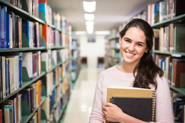 図書館で 高校図書館で働く本を持つかなり女性の学生 — ストック写真