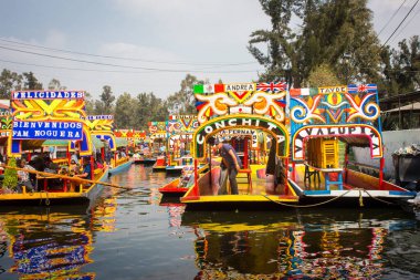 Meksikalı işçiler Xochimilco 'da renkli trajinera tekneleri boyuyorlar.