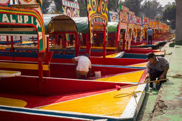 Trabajadores mexicanos pintando coloridas trayectineras de barcos en xochimilco — Foto de Stock