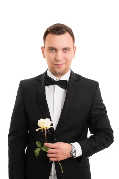 Pohledný mladý muž v obleku drží květinu — Stock fotografie