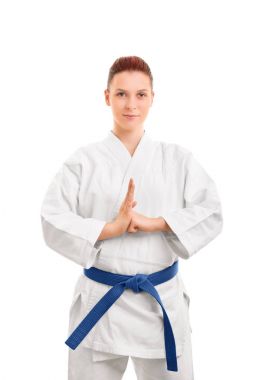 Smiling girl  in white kimono performing a hand salute