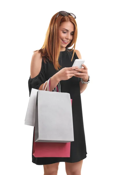 Ragazza con borse della spesa digitando sul suo telefono — Foto Stock