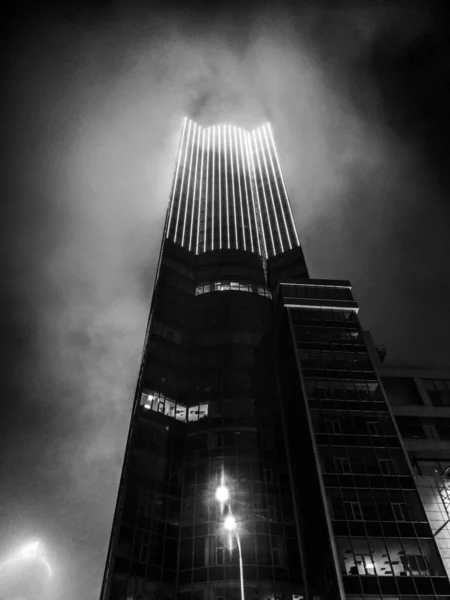 Black and white photograph of a skyscraper in fog — Stock Photo, Image