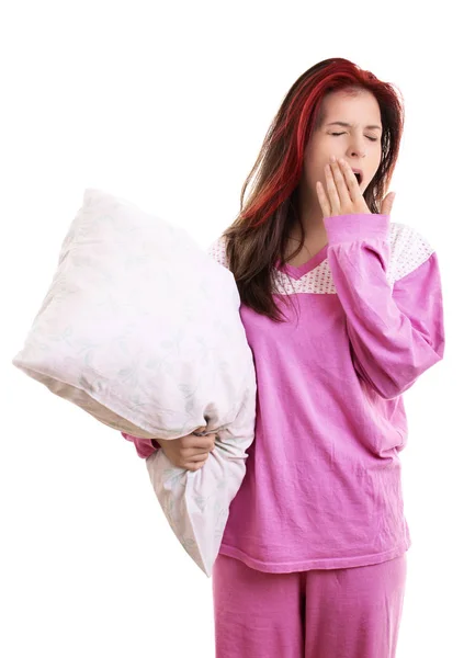 Jovencita cansada en pijama sosteniendo una almohada y bostezando —  Fotos de Stock