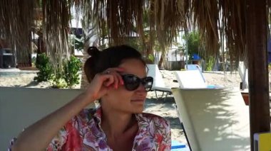 Kumlu plajda dinlenen zarif genç kadın .