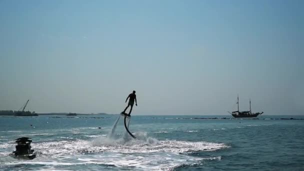 Flyboard denizin üzerinde eğleniyor bir adam silüeti. — Stok video