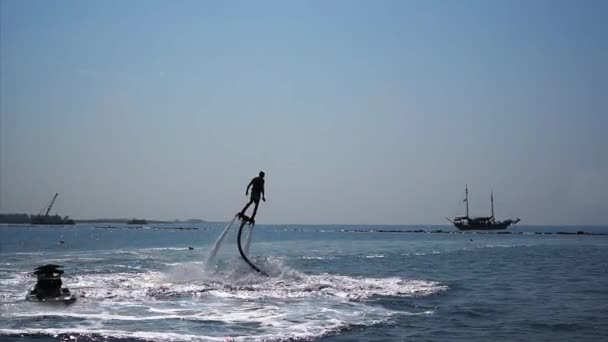 Silhueta de um homem se divertindo em Flyboard no mar . — Vídeo de Stock