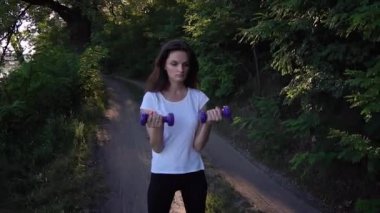 Neşeli kız parkta halter kaldırma