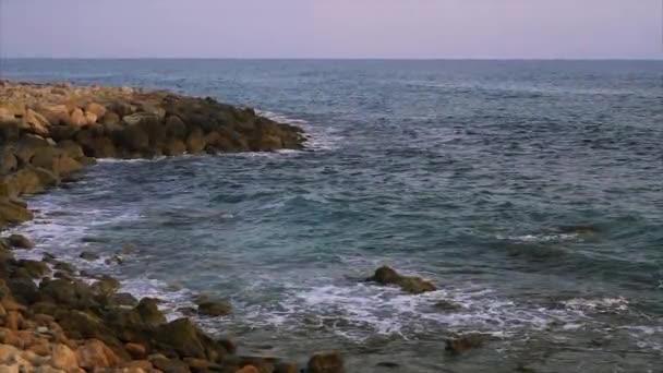 Waves breaking against rocks on sea shoreline. — Stock Video