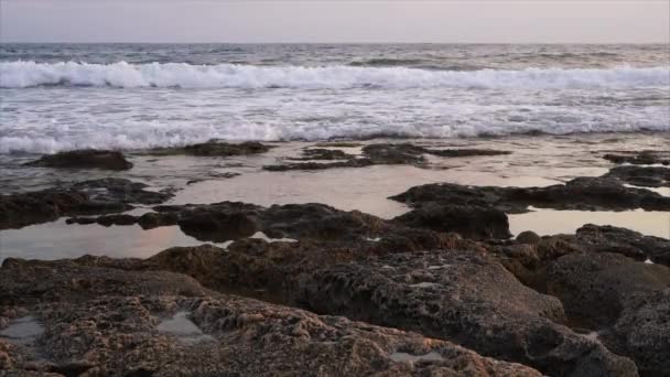 समुद्र तट पर चट्टानों के खिलाफ लहरें टूट रही हैं . — स्टॉक वीडियो