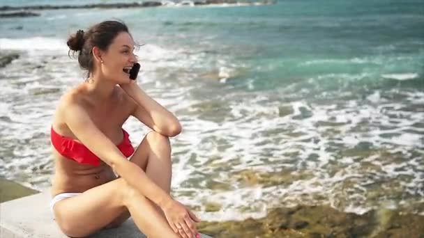 Mujer joven hablando por celular en la playa — Vídeos de Stock
