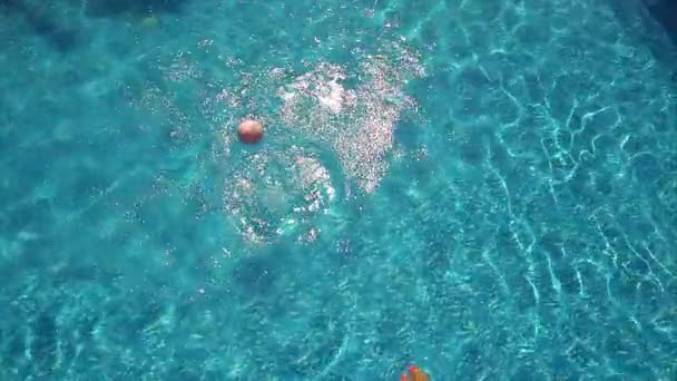 Young woman playing with ball on swimming pool — Stock Video