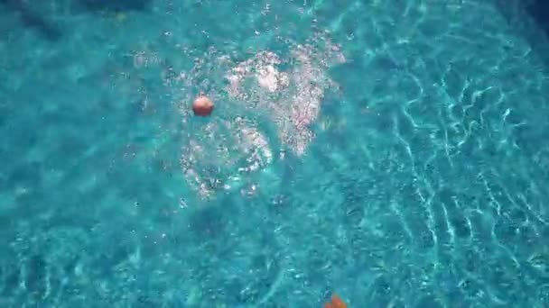 Young woman playing with ball on swimming pool — Stock Video