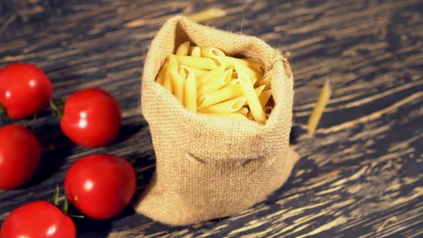 Tomato and pasta on wooden background — Stock Video
