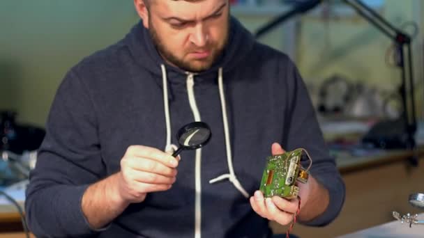 Ingeniero mirando una placa de circuito . — Vídeos de Stock