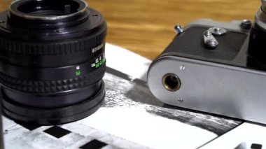 Vintage 35mm kameralar, lensler, fotoğraf ve film yığılı.
