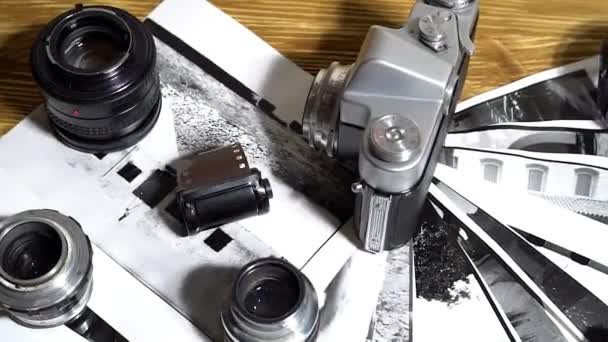 Vintage 35mm cameras, lenses, photos and film are piled up. — Stock Video