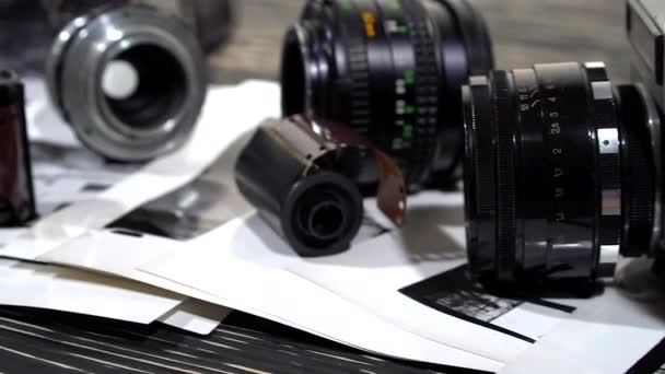 Vintage 35mm cameras, lenses, photos and film are piled up. — Stock Video