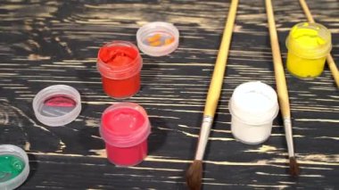 Varicolored boya guaj kavanoz fırçalar ahşap arka plan ile bir sürü