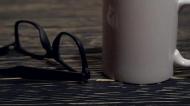 Gözlük, kalem ve defter siyah ahşap zemin üzerine.