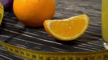 Portakal, suyu, halter ve ahşap arka plan üzerinde ölçüm bandı.