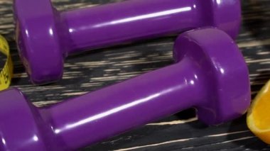 Portakal, halter ve ahşap arka plan üzerinde ölçüm bandı.