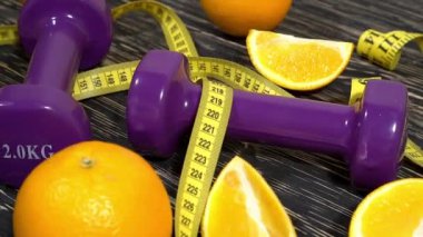 Portakal, suyu, halter ve ahşap arka plan üzerinde ölçüm bandı.