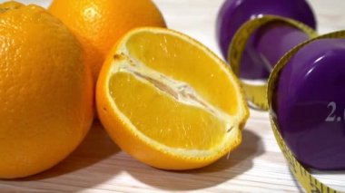 Portakal, suyu, halter ve ahşap arka plan üzerinde ölçüm bandı.