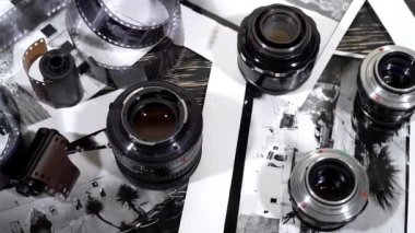 Vintage 35mm kameralar, lensler, fotoğraf ve film yığılı.