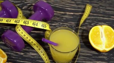 Portakal, suyu, halter ve ahşap arka plan üzerinde ölçüm bandı.