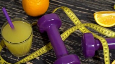 Portakal, suyu, halter ve ahşap arka plan üzerinde ölçüm bandı.