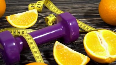 Portakal, suyu, halter ve ahşap arka plan üzerinde ölçüm bandı.