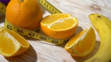 Portakal, suyu, halter ve ahşap arka plan üzerinde ölçüm bandı.